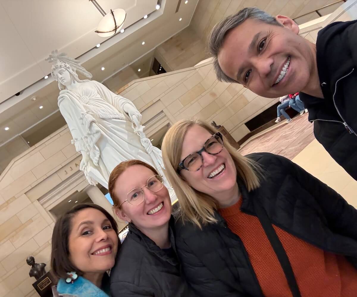 Participants touring the US Capitol, posing near the plaster model of the Statue of Freedom