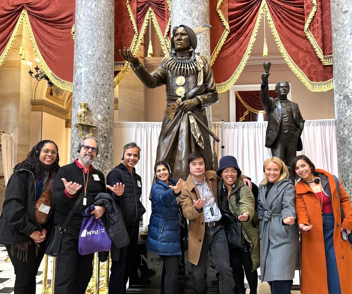 Writing Salon participants touring the US Capitol, posing in front of the Chief Standing Bear statue