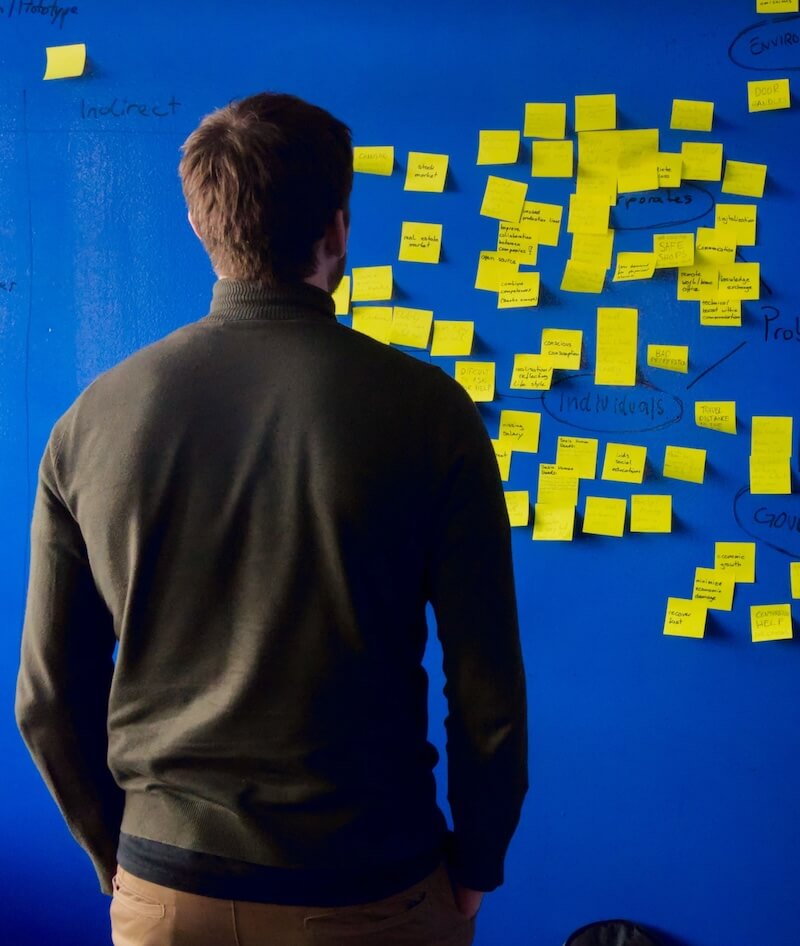 Person looking at sticky notes on a wall