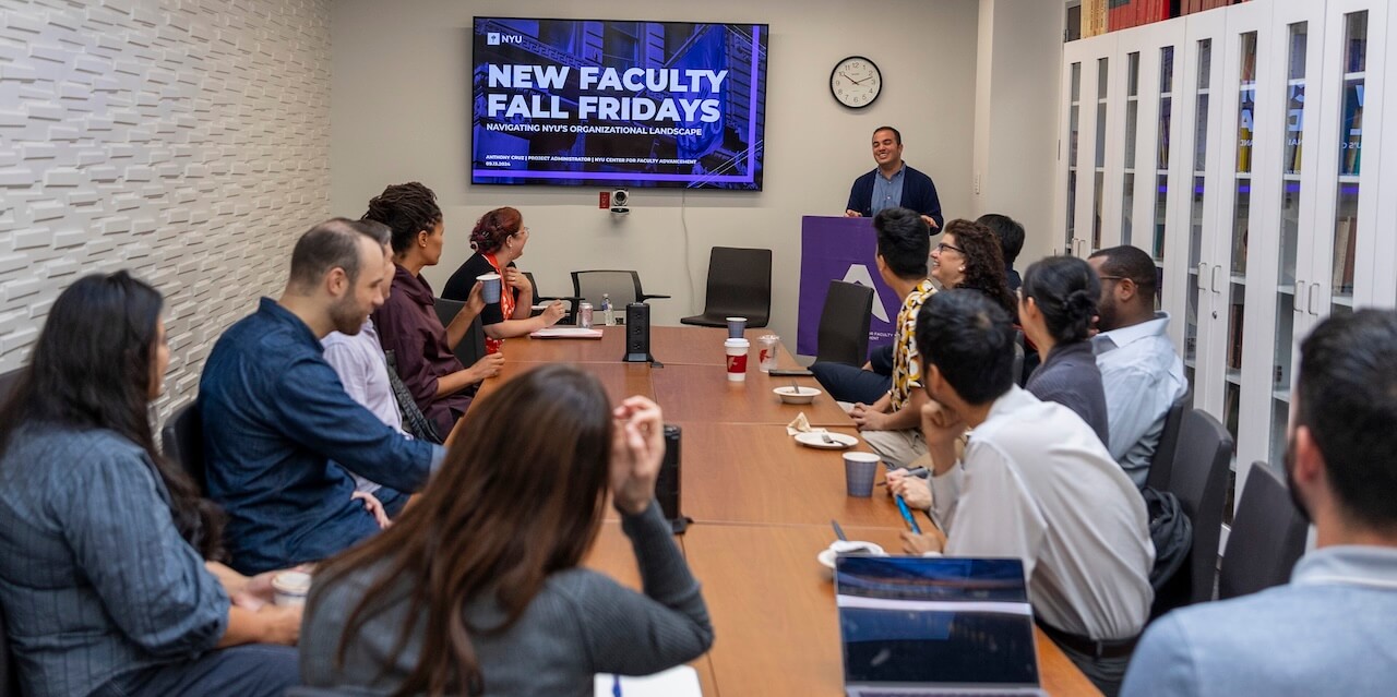 Anthony Cruz giving a slide presentation to a conference room full of NYU faculty