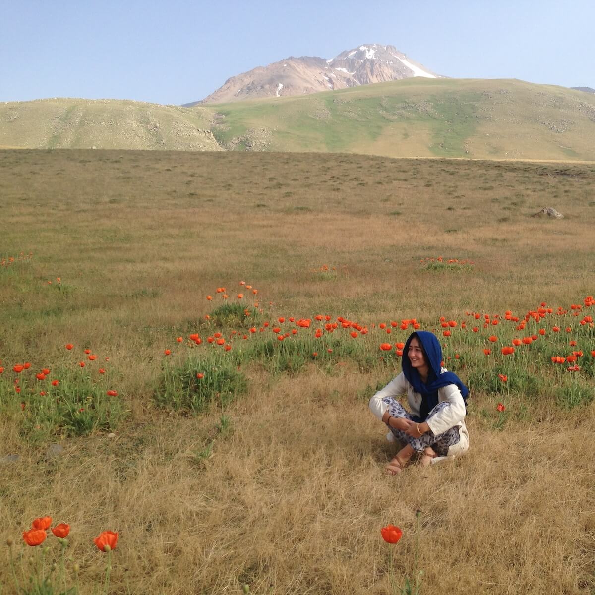 Saba Rouhani sitting in a field of flowers